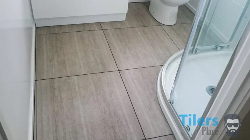Large format tiles cut to fit a small bathroom floor