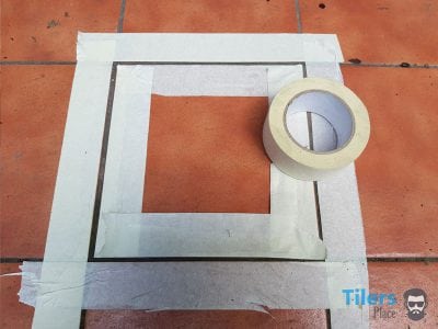 Applying masking tape around tile